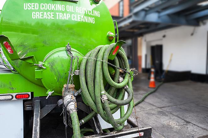 a grease trap pumping service in action at a commercial building in Bayport